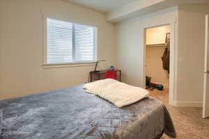 Bedroom with a walk in closet, carpet floors, and a closet