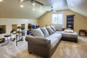 Carpeted living room with ceiling fan, vaulted ceiling, a textured ceiling, and recessed lighting