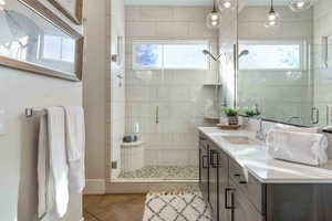 Bathroom featuring vanity, tile patterned floors, a stall shower, and plenty of natural light