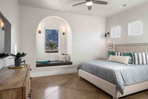 Bedroom with arched walkways, concrete flooring, and a ceiling fan