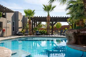 Outdoor pool with a pergola and a patio