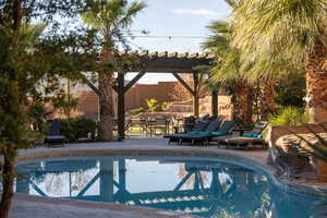 View of pool featuring a pergola, a patio area, and an outdoor hangout area