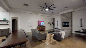 Living area featuring ceiling fan, a large fireplace, and arched walkways