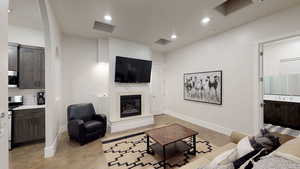 Living area with a glass covered fireplace and recessed lighting