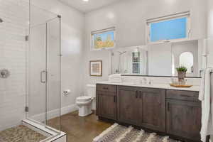 Bathroom with vanity, a stall shower, and decorative backsplash