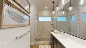 Bathroom featuring vanity, a stall shower, tile patterned flooring, and recessed lighting