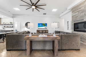 Living room with a ceiling fan and concrete flooring