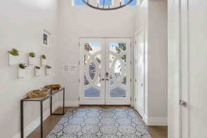 Foyer with healthy amount of natural light, french doors, and a towering ceiling