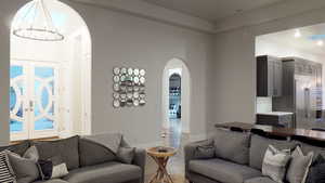 Living room featuring arched walkways, a chandelier, and recessed lighting