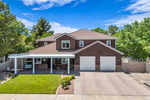 View of front facade featuring a porch, concrete driveway, stone siding, a tile roof, and an attached garage