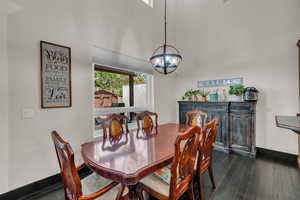 Dining area with dark wood finished floors and a chandelier