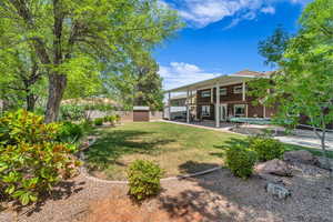 Fenced yard with a storage unit and a patio