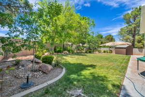 Fenced backyard featuring a storage unit