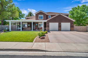 View of front of property featuring stone siding, driveway, stucco siding, a porch, and an attached garage