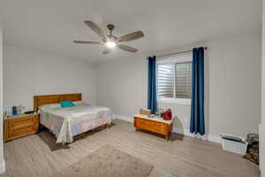 Bedroom with light wood-style floors and ceiling fan