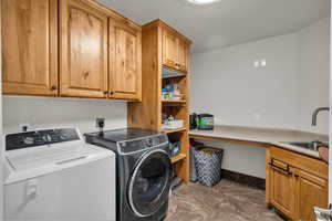 Washroom featuring washer and clothes dryer and cabinet space