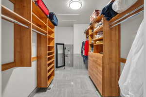 Spacious closet featuring attic access