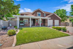 Traditional-style home featuring stone siding, stucco siding, driveway, an attached garage, and a porch