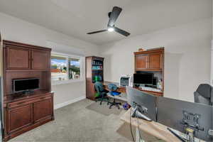 Carpeted office with ceiling fan and baseboards