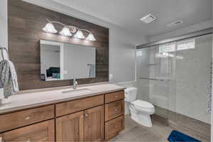 Bathroom featuring vanity, a shower stall, connected bathroom, and tile patterned flooring