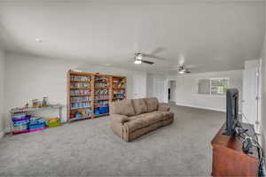 Living room with carpet flooring and a ceiling fan