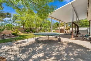Fenced backyard with a storage unit and a patio area