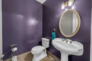 Half bath with toilet and baseboards