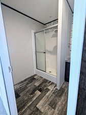 Full bathroom with wood finished floors and a stall shower
