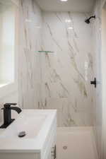 Bathroom with vanity and tiled shower