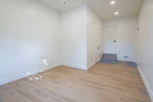 Empty room with light wood-type flooring and recessed lighting
