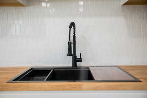 Kitchen view of butcher block counters and tasteful backsplash