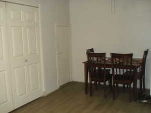 Dining area featuring wood finished floors and hidden pantry, washer and dryer area