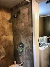 Front House Bathroom & Laundry room view of washer / clothes dryer and shower / bathtub combination