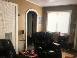 Front House Living area featuring arched walkways and a textured wall