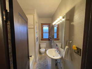 Full bath with tile patterned floors and a textured wall