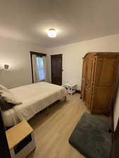Bedroom featuring light wood finished floors and a textured ceiling