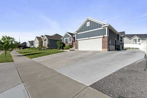 Ranch-style house featuring board and batten siding, a residential view, brick siding, and driveway