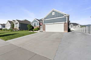 Craftsman inspired home featuring board and batten siding, driveway, brick siding, and a residential view