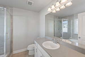 Full bath featuring vanity, a stall shower, and tile patterned floors