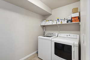 Laundry area with washing machine and clothes dryer and light tile patterned floors