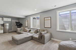 Living area featuring light carpet, plenty of natural light, and recessed lighting