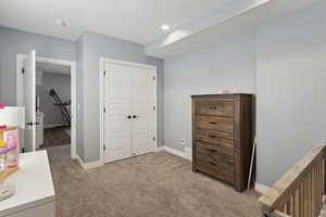 Bedroom featuring light colored carpet and a closet