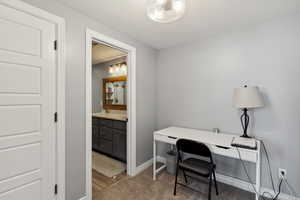 Office space with light wood-type flooring and a textured ceiling