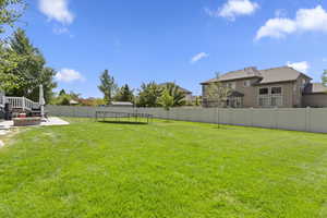 Fenced backyard featuring a patio and a trampoline