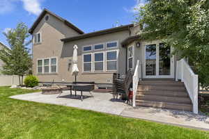 Rear view of house featuring stucco siding, an outdoor fire pit, and a patio area