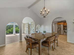 Dining area featuring arched walkways, a chandelier, high vaulted ceiling, light tile patterned floors, and beamed ceiling