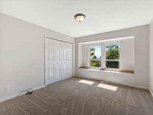 Unfurnished bedroom with carpet and a closet