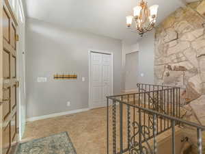Hallway featuring an upstairs landing and a chandelier