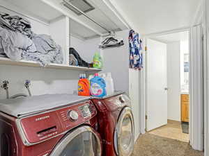 Washroom with separate washer and dryer, light tile patterned flooring, and light carpet