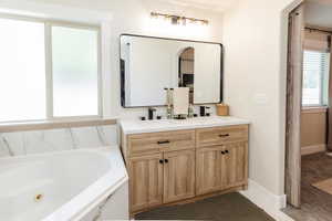 Bathroom featuring double vanity and a jetted tub